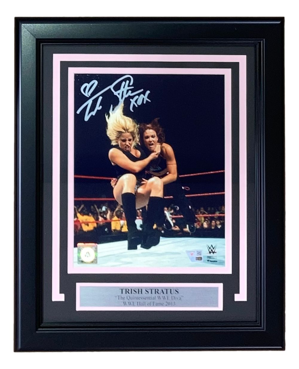 Sports Integrity’s Trish Stratus Signed Framed 8x10 WWE Photo vs Lita Fanatics features Trish in action, includes her autograph at the top, and a plaque that reads “Trish Stratus, The Quintessential WWE Diva, Hall of Fame 2013.”.