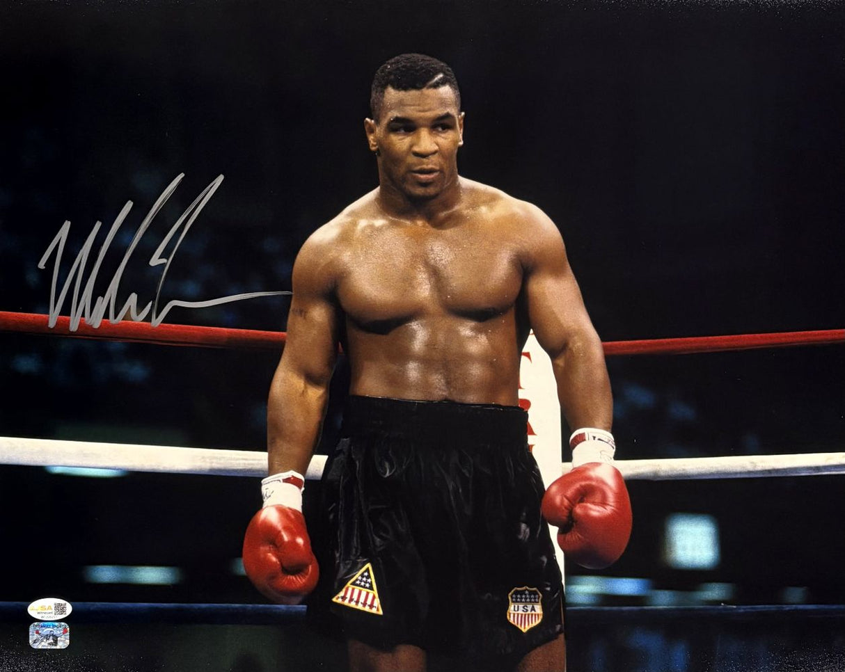 A determined Mike Tyson stands in the ring wearing red gloves and black shorts. This Sports Integrity 16x20 photo features his signature on the left side and comes with a JSA QR hologram for authenticity.
