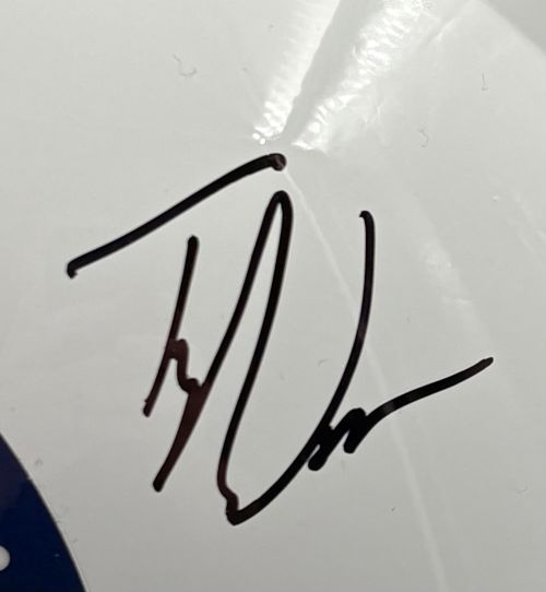 Black autograph in marker with loops and angled lines on a shiny white Indianapolis Colts FS Speed Replica Helmet, signed by Tyler Warren. A blue section with white dots is visible; includes case. Brand: Sports Integrity.