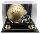 A gold football helmet with a black autograph is showcased in the Sports Integrity Deluxe Acrylic Mini Helmet Display Case, featuring a clear enclosure with a black base and gold accents.
