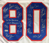 The Sports Integrity 1980 USA Hockey Signed White Olympic Jersey features the blue and red number 80, multiple signatures from 18 players, and "Do you believe in miracles?" written inside the left zero.