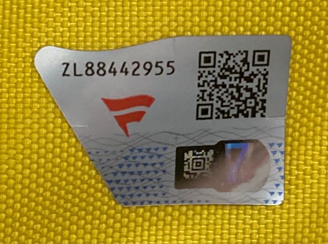 A silver security sticker with the code ZL88442955, two QR codes, a red F logo, and blue wavy patterns is seen on a yellow 2008 Open Championship Royal Birkdale PGA Issued Golf Flag from Sports Integrity.