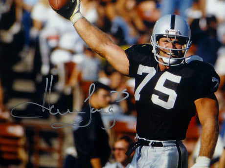 Howie Long Autographed Raiders 16x20 Holding Ball Photo- JSA Witnessed Auth