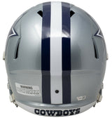 The Sports Integrity CeeDee Lamb Signed Dallas Cowboys Full Size Speed Replica Helmet features a silver design with a white and blue center stripe, "COWBOYS" on the lower back, and a warning label on the left side.