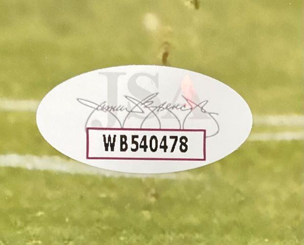 An oval JSA authentication sticker with code WB540478 appears on the Jeremiah Trotter Jr Signed 8x10 Philadelphia Eagles Photo by Sports Integrity, featuring a grass background, faint signature, and the letters JSA behind the code.