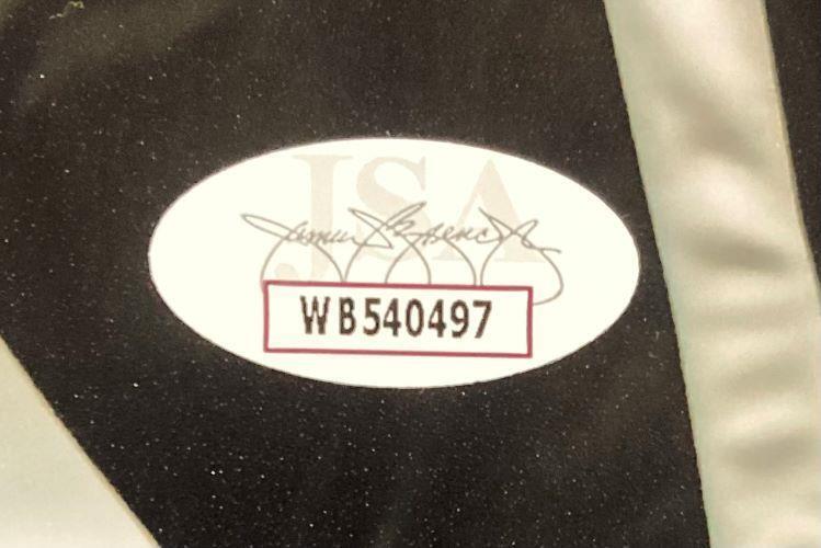 Close-up of a Sports Integrity oval authentication sticker with signature, faint JSA background text, and code WB540497 on an 8x10 Clemson Tigers photo signed by Jeremiah Trotter Jr.