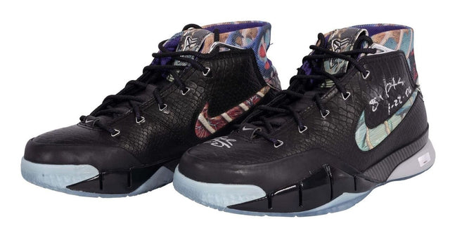 A pair of black Nike Zoom Kobe I Prelude high-top basketball shoes with textured uppers, multicolored inner lining, icy blue soles, and signed by Kobe Bryant (81 PTS), offered by Sports Integrity.