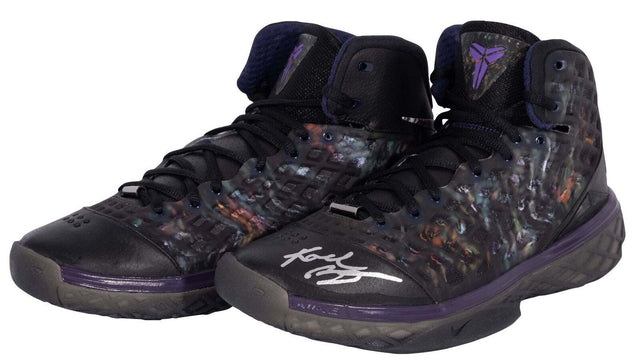A pair of Kobe Bryant Lakers Signed Nike Zoom Kobe III Prelude Shoes by Sports Integrity, featuring translucent sides, purple accents, the Kobe Bryant logo on the tongue, and a white autograph on one toe.