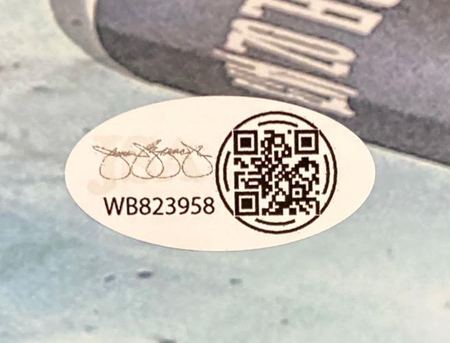 A Bo Nickal Signed 11x14 UFC Punch Photo by Sports Integrity features an oval sticker with a QR code, serial number WB823958, and a stylized signature on a blue and gray surface.