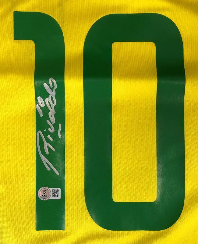 The Sports Integrity Rivaldo Signed Brazil Nike Soccer Jersey BAS features a large green number 10, signed in silver by Rivaldo, with a small authentication sticker and QR code at the bottom.