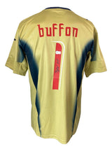 The Sports Integrity Gianluigi Buffon Signed Italy Puma Gold Soccer Jersey features dark blue accents, Buffon's name, and the number 1 in red with his signature on the back.
