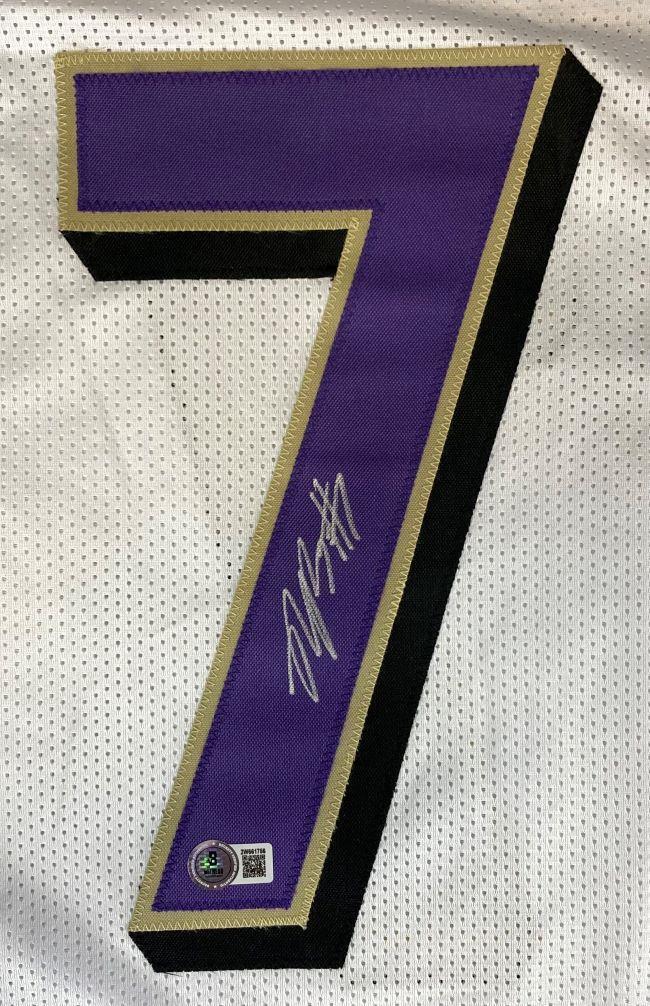 A Rashod Bateman Baltimore Signed White Football Jersey by Sports Integrity features a large purple number 7 with gold and black borders on white mesh, signed in silver, plus a round QR authentication sticker below the signature.