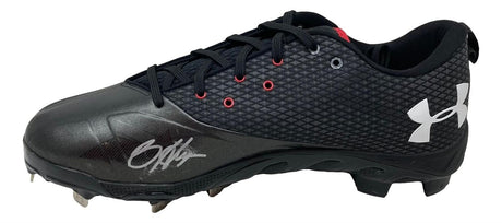 A Bryce Harper signed pair of black Phillies Under Armour cleats by Sports Integrity, featuring red eyelets, a white logo, and a silver autograph on the toe, seen from the side.