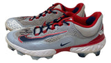 A pair of Paul Goldschmidt Twice Signed 2023 Game Used Cardinals Nike Cleats by Sports Integrity, featuring textured details, molded studs, navy blue laces, and black swoosh logos.