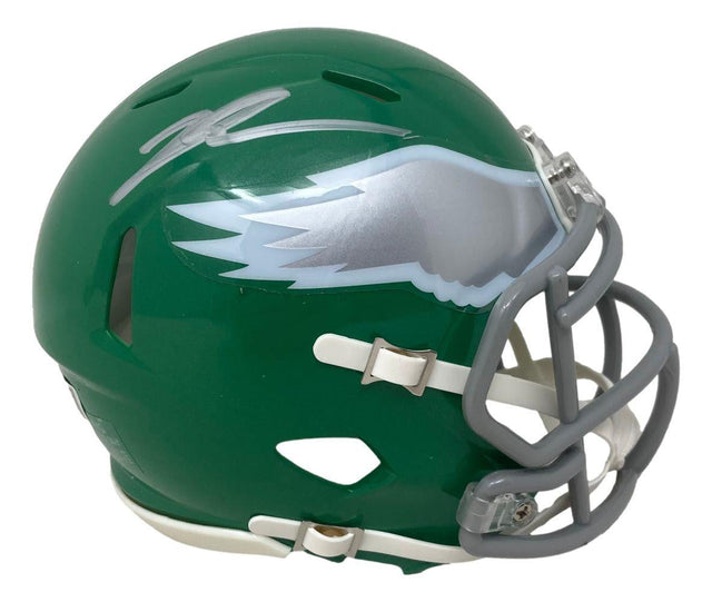 The Sports Integrity Jalen Carter Signed Philadelphia Eagles Kelly Green Mini Speed Helmet BAS features a silver wing design, gray facemask, white chin strap, and an autograph on top.