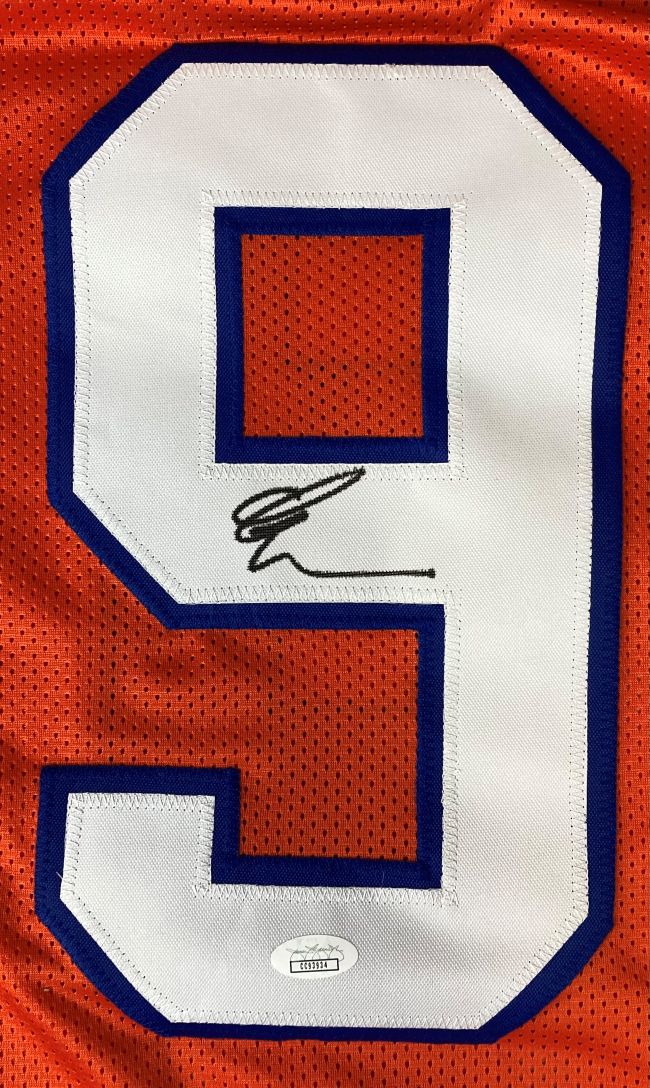 A large white number 9 with blue trim is sewn onto orange mesh on this Sports Integrity custom Adam Sandler “The Waterboy” Boucher football jersey. The number features a black signature and JSA authentication sticker (CC93934) at the bottom.