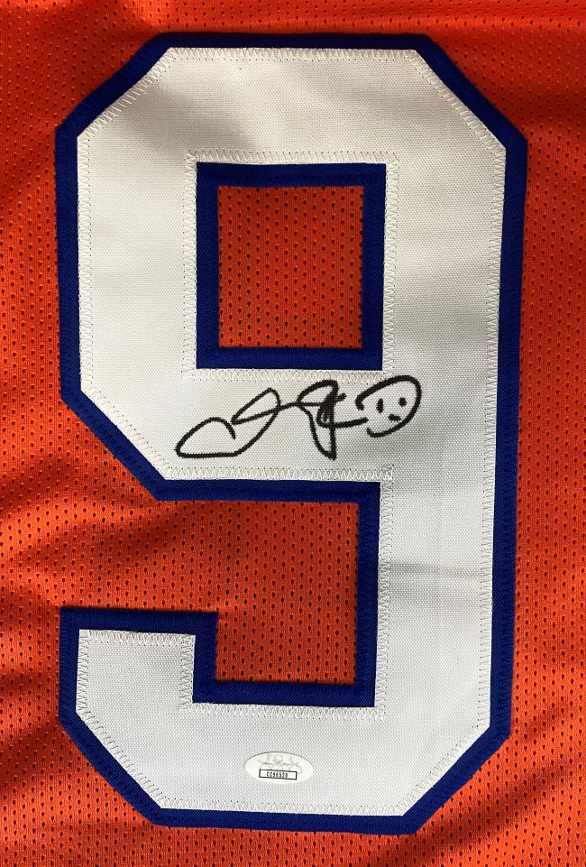 The Sports Integrity Adam Sandler "The Waterboy" Boucher football jersey features an orange design with a large white and blue number 9, a black signature in the center, and a JSA authentication sticker at the bottom.