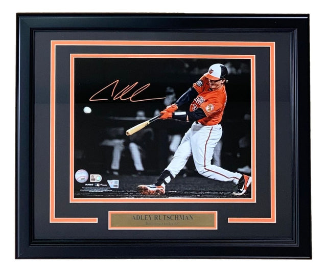 Sports Integrity's Adley Rutschman Signed Framed 11x14 Baltimore Orioles Photo features the player in a white and orange uniform swinging a bat, with his autograph above and a nameplate within an orange and black accented frame.