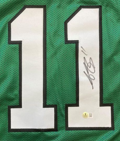 The AJ Brown Philadelphia Kelly Green Football Jersey by Sports Integrity features large white number 11s outlined in black, with one digit displaying a bold black autograph and a round BAS authentication sticker at its base.
