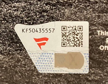 A close-up of a security sticker with a red logo, serial number KF50435557, QR code, and hologram on the Alec Bohm Signed Framed 11x14 Philadelphia Phillies Photo by Sports Integrity.