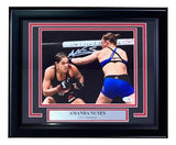 Sports Integrity Amanda Nunes Signed Framed 8x10 UFC Rousey Fight Photo features two female MMA fighters in the octagon, Nunes throwing a punch, with a “AMANDA NUNES UFC Champion” plaque and her white signature above. JSA QR Hologram included.
