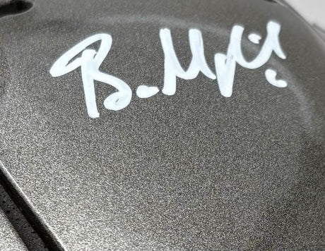 Close-up of a Baker Mayfield signed Tampa Bay Buccaneers FS Authentic SpeedFlex Helmet by Sports Integrity, showing his bold white autograph on the metallic gray surface.