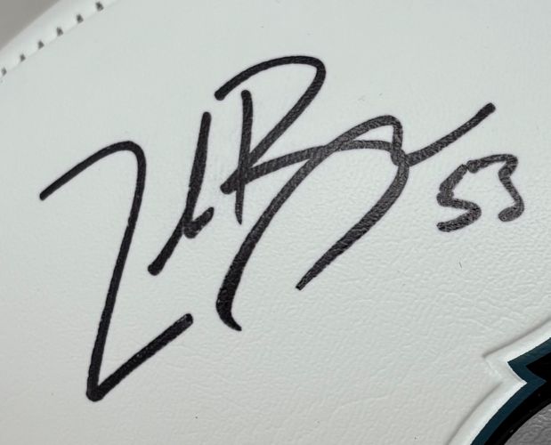 Close-up of Zack Baun's black autograph with number 58 on a white Philadelphia Eagles logo football by Sports Integrity; teal, black, and white part of the Eagles logo is visible in the lower right corner. Includes BAS authentication and display case.
