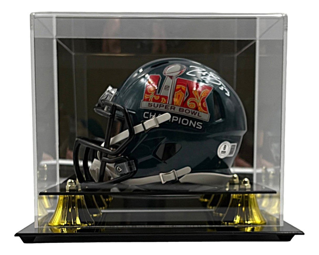 A Zack Baun Signed Philadelphia Eagles Super Bowl 59 Mini Speed Helmet by Sports Integrity is showcased in a clear display case with a black base and gold corner accents.
