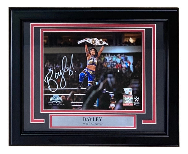 Bayley Signed Framed 8x10 WWE Wrestlemania XL Photo by Sports Integrity, features Bayley holding a title belt in blue gear with autograph, red-bordered frame, and “BAYLEY WWE Superstar” plaque.