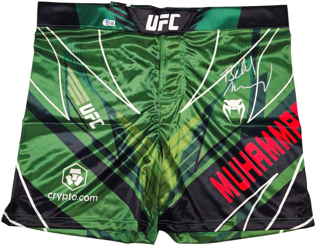 Belal Muhammad Signed Custom Green MMA Fight Trunks by Sports Integrity feature geometric patterns, UFC, Venum, and crypto.com logos, MUHAMMAD in red, and an autograph on the right side.
