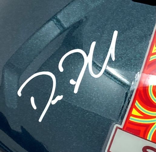 A white cursive signature appears on this dark, glossy Philadelphia Eagles FS Super Bowl 59 LIX replica helmet from Sports Integrity, next to a colorful sticker with orange, yellow, and green swirls.