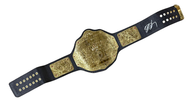 The Bill Goldberg WCW Signed Full Size Big Gold Heavyweight Championship by Sports Integrity features intricate gold designs on a black strap, a white autograph on the right end, and multiple gold buttons for adjustment.