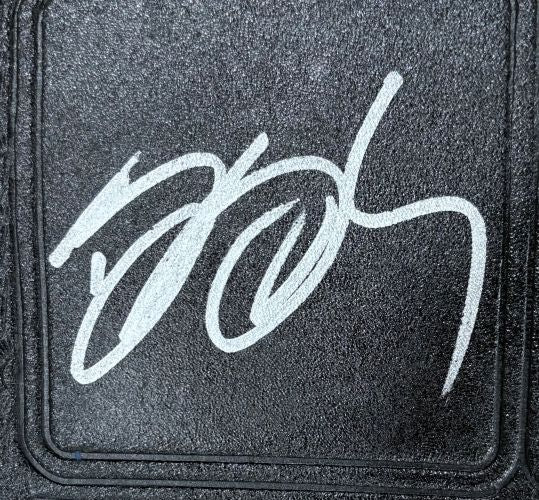 A bold, white autograph is inscribed in a looping style on the textured black surface of the Bill Goldberg WCW Signed Full Size Big Gold Heavyweight Championship by Sports Integrity.