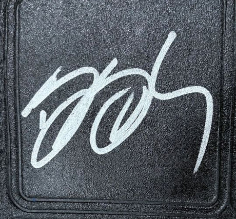 A bold, white autograph is inscribed in a looping style on the textured black surface of the Bill Goldberg WCW Signed Full Size Big Gold Heavyweight Championship by Sports Integrity.