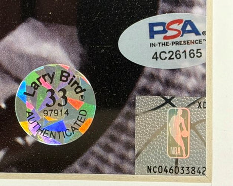Close-up of a Larry Bird Signed Framed 16x20 Boston Celtics w/ Auerbach Photo (Sports Integrity) shows a holographic '33 AUTHENTICATED' sticker, PSA/DNA label code 4C26165, and NBA logo with number NC046033842.