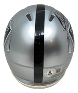 The Bo Jackson Signed Oakland Raiders Mini Speed Helmet by Sports Integrity features a silver design with a black center stripe, Raiders logos on each side, his signature on top, and a visible BAS ITP certification sticker.