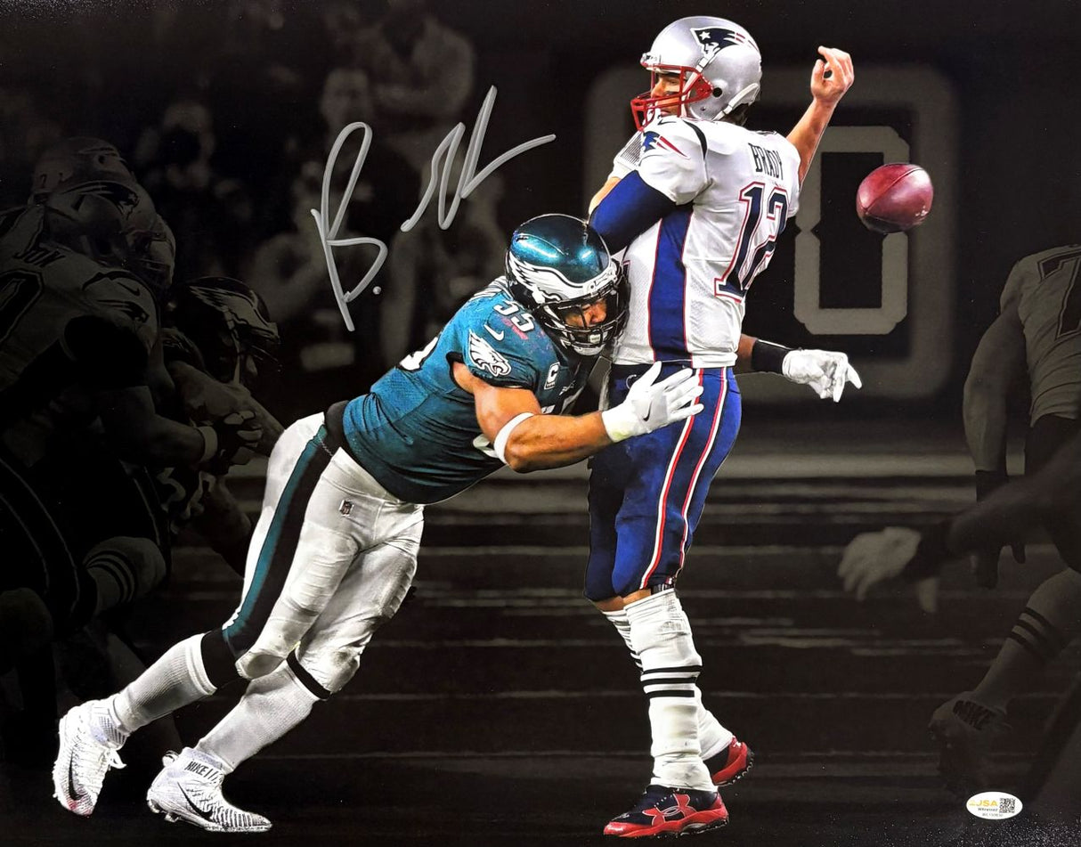 A dynamic, color Brandon Graham tackles Tom Brady in this signed 16x20 Eagles Strip Sack Spotlight Photo (Sports Integrity), with a black and white background and a large signature. Authenticated by JSA QR.