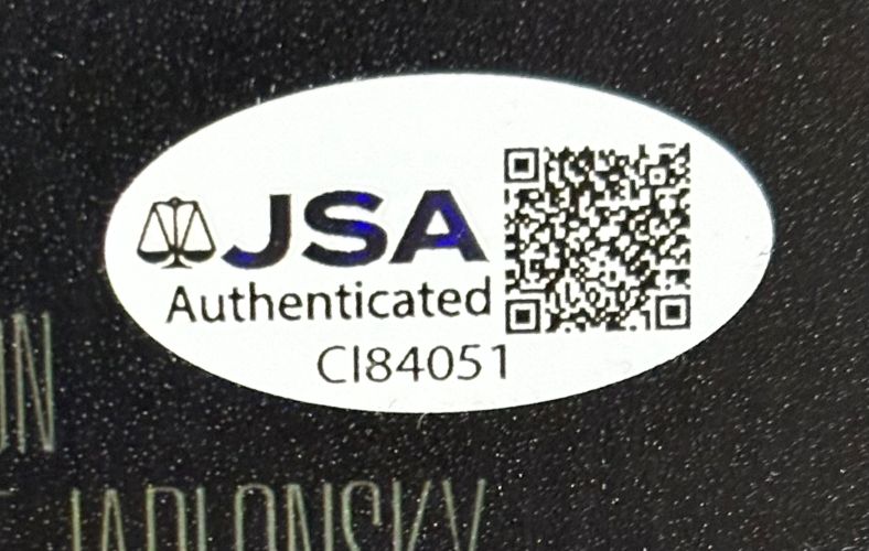 A white oval JSA Authenticated sticker with a scale icon, QR code, and CI84051 appears on the Sports Integrity Andrew Bryniarski Signed 11x17 Texas Chainsaw Massacre Leatherface Photo.