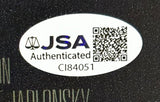 A white oval JSA Authenticated sticker with a scale icon, QR code, and CI84051 appears on the Sports Integrity Andrew Bryniarski Signed 11x17 Texas Chainsaw Massacre Leatherface Photo.