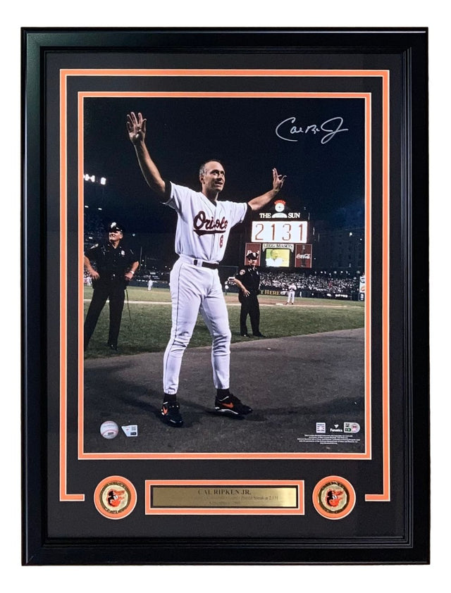 The Sports Integrity Cal Ripken Jr Signed Framed 16x20 Orioles Game 2131 Photo features him in uniform with arms raised, autograph, team logos, and a nameplate—all showcased in a collectible display by Fanatics.