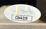 A white oval JSA sticker with faint multicolored text and signatures, featuring bold code CD44219, is affixed to the Charlie Hunnam Signed Framed 8x10 Pacific Rim Photo by Sports Integrity.