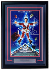 The Sports Integrity Chevy Chase Signed Framed 11x17 Lampoon’s Christmas Vacation Photo BAS features the iconic scene with a man shocked by Christmas lights, “YULE CRACK UP!” above, and a plaque with Chevy Chase’s name.