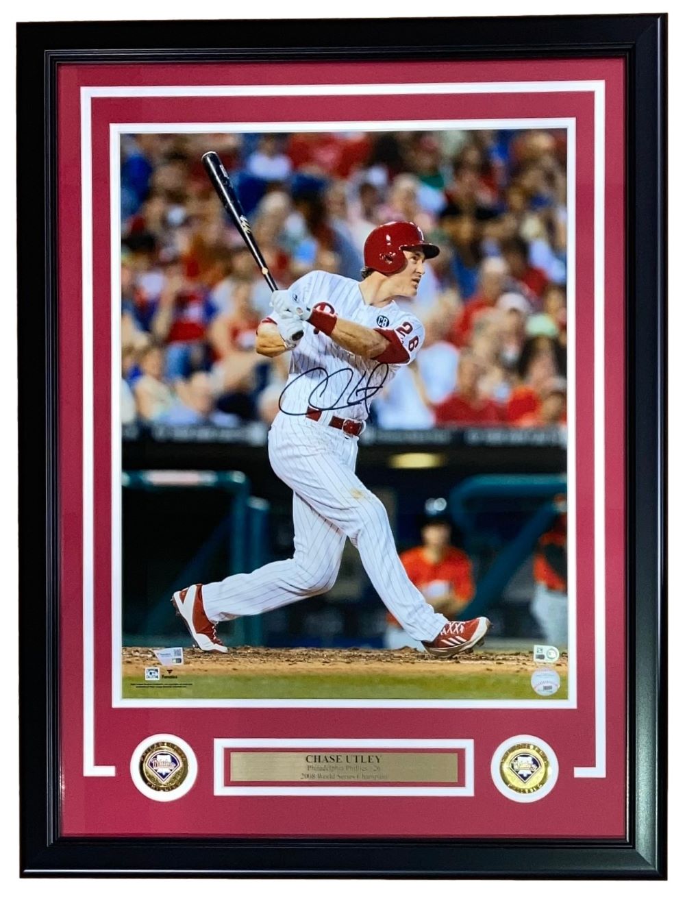 A Chase Utley Signed Framed 16x20 Philadelphia Phillies Photo by Sports Integrity, featuring Utley in a white pinstripe uniform swinging a bat, with two commemorative patches and a nameplate included at the bottom of the frame.