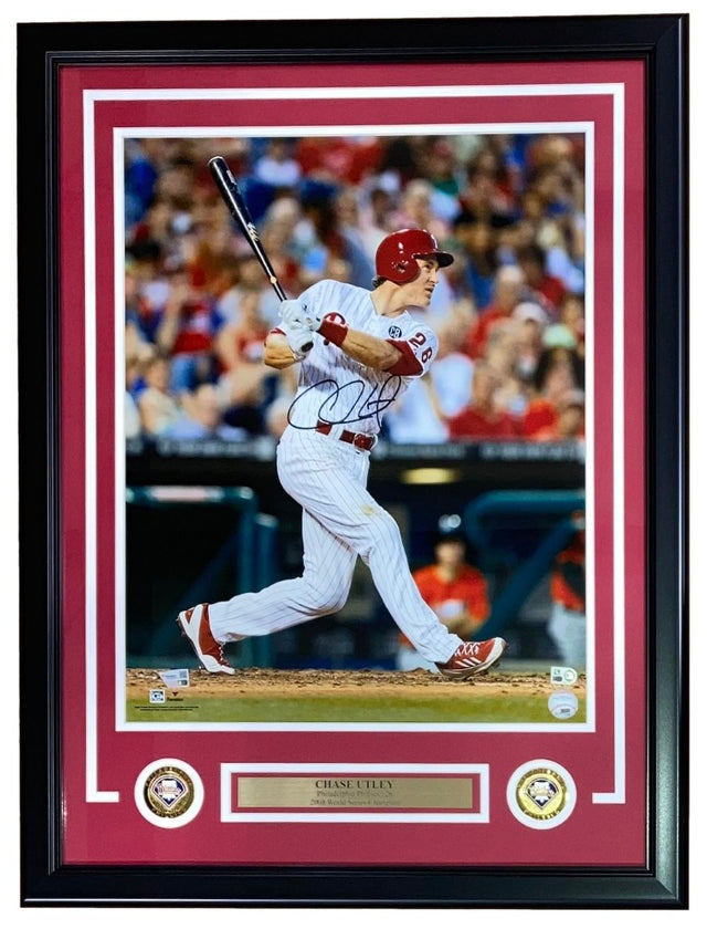 A Chase Utley Signed Framed 16x20 Philadelphia Phillies Photo by Sports Integrity, featuring Utley in a white pinstripe uniform swinging a bat, with two commemorative patches and a nameplate included at the bottom of the frame.