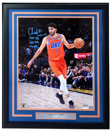 Sports Integrity presents a Chet Holmgren signed framed 16x20 Oklahoma City Thunder photo with 2023 stat inscription (JSA), featuring him in an orange jersey dribbling on court and displaying a plaque reading “Chet Holmgren 2023 NBA Champion.”.