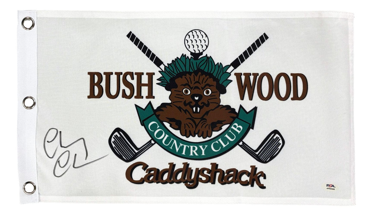 The Sports Integrity Chevy Chase Signed Bush Wood Caddyshack Golf Flag features a cartoon gopher, crossed clubs, golf ball, Bushwood Country Club text, and Chevy Chase’s large black signature. Includes PSA/DNA hologram.