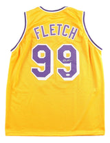 A Chevy Chase signed Los Angeles yellow Fletch basketball jersey by Sports Integrity, featuring purple and white trim with "FLETCH" and number 99 on the back; includes JSA hologram.