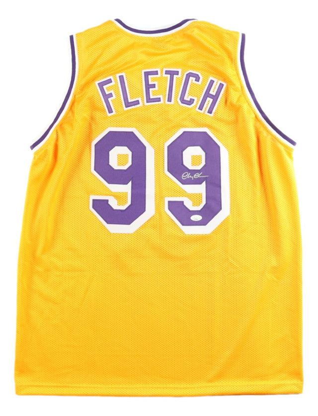 A Chevy Chase signed Los Angeles yellow Fletch basketball jersey by Sports Integrity, featuring purple and white trim with "FLETCH" and number 99 on the back; includes JSA hologram.