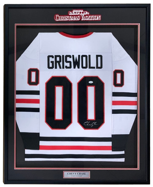 The Sports Integrity Chevy Chase Signed Framed Lampoon’s Christmas Vacation White Griswold Jersey (JSA) features GRISWOLD and 00 in black, a Chevy Chase nameplate, autograph, and display referencing the film.