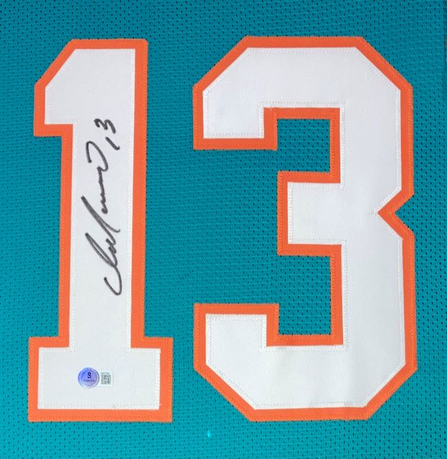 The Sports Integrity Dan Marino Miami Signed Framed Custom Teal Football Jersey BAS features a large white and orange #13 with Dan Marino’s black ink autograph on the “1” and an authentication sticker below.
